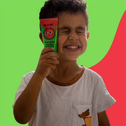 Happy child holding monster melon toothpaste with cheeky smile